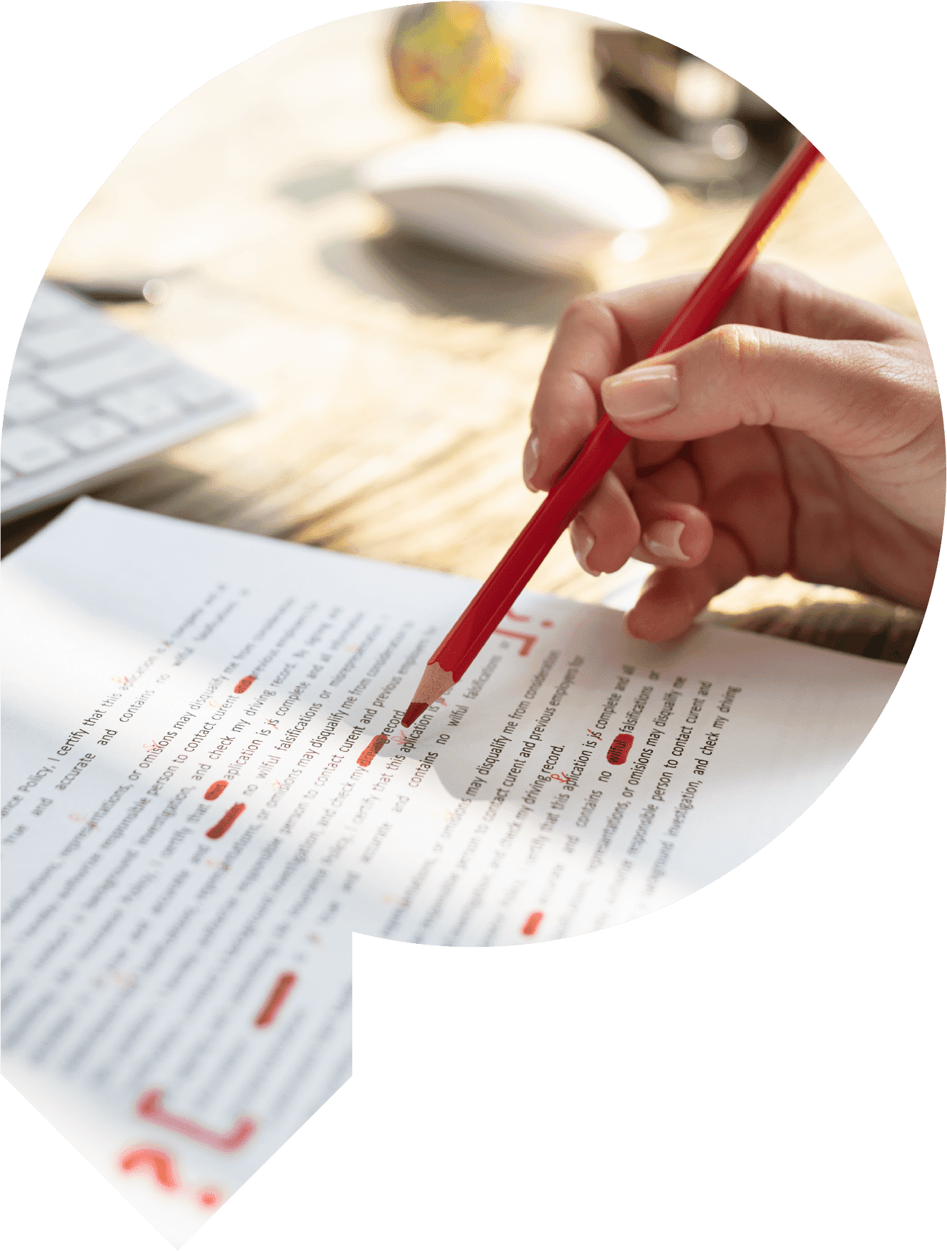 Person reviewing and making corrections using a red pencil to a typed document.