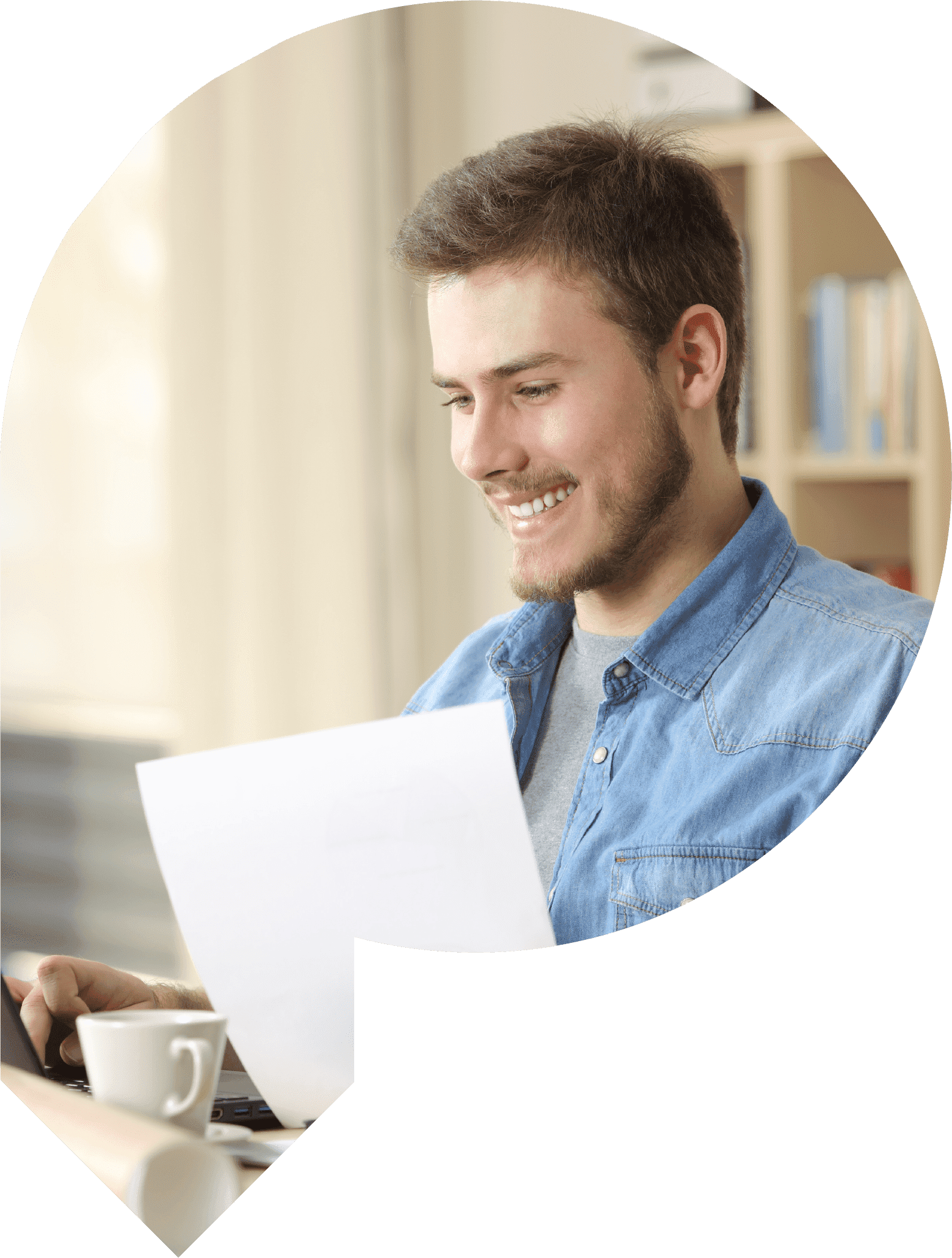 Student smiling whilst holding a document and looking at the computer screen.